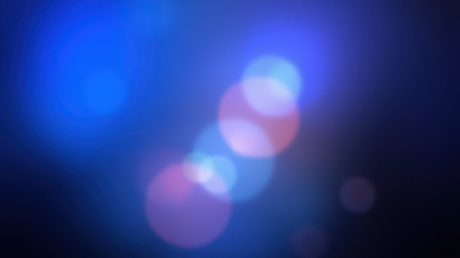 Vibrant bokeh lights shimmering in a deep blue background during an evening event